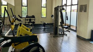A gym with cardio machines, weightlifting equipment, and a mirror. - Day Use Inn At Serpong Green View Apartment Bsd (South Tangerang)