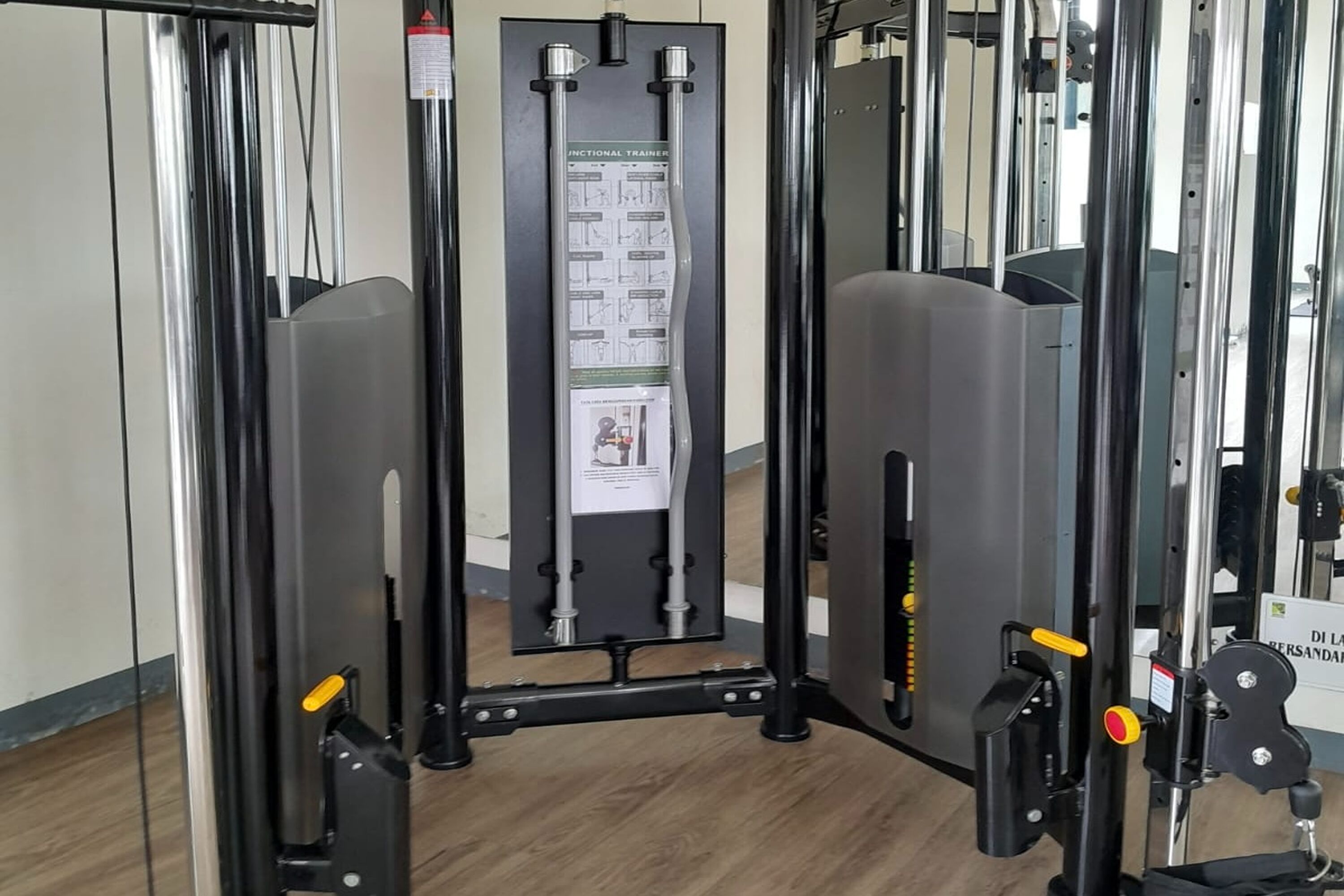 Ein Fitnessstudio mit Squat-Rack, Bänken und Gewichtsplatten.