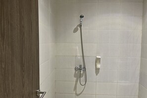 Eine Dusche mit Handbrause und verstellbarer Armatur an der Wand.
