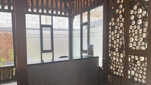 A room with a large window, a wooden partition with circular cutouts, and a bench. - Gb 2 Backpacker Borobudur (Borobudur)