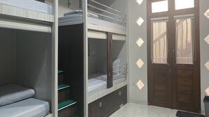 A room with bunk beds, a wardrobe, and a door with patterned glass panels. - Gb 2 Backpacker Borobudur (Borobudur)