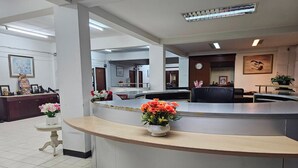 A reception area with a curved counter, a clock, and framed artwork on the walls.