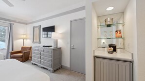 Ein Hotelzimmer mit Bett, Schminktisch, Stuhl, Spiegel und Ablagefläche mit Dekoration.