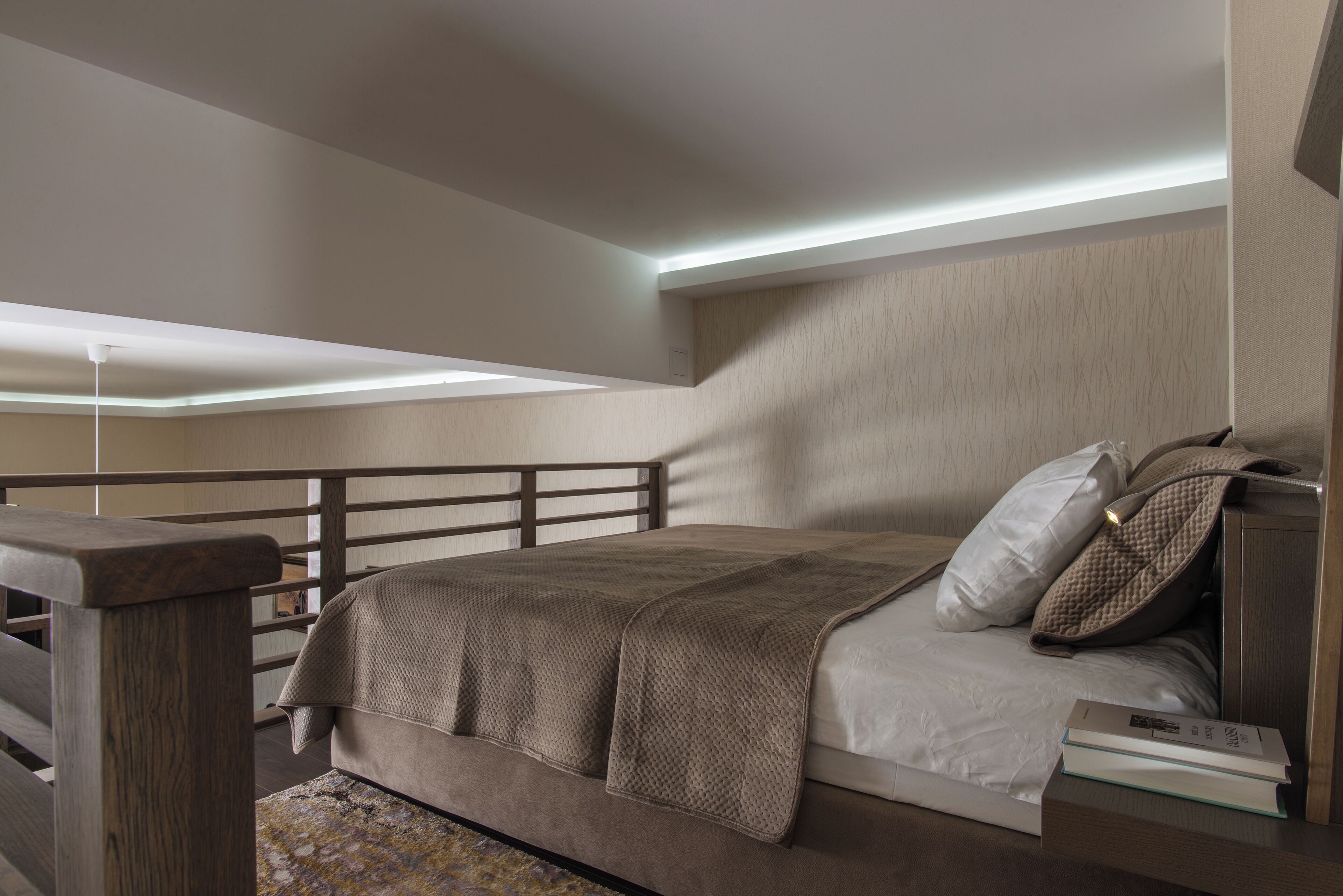 A bedroom with a bed, wooden headboard, bedside tables, and a ceiling light fixture.