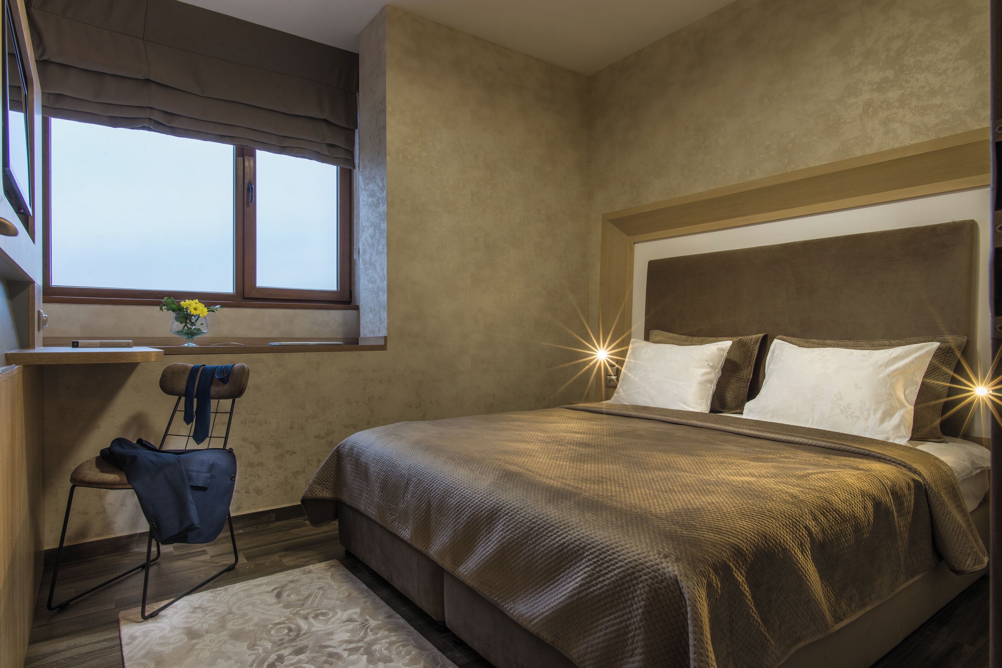Un dormitorio con una cama grande, un escritorio y una silla.
