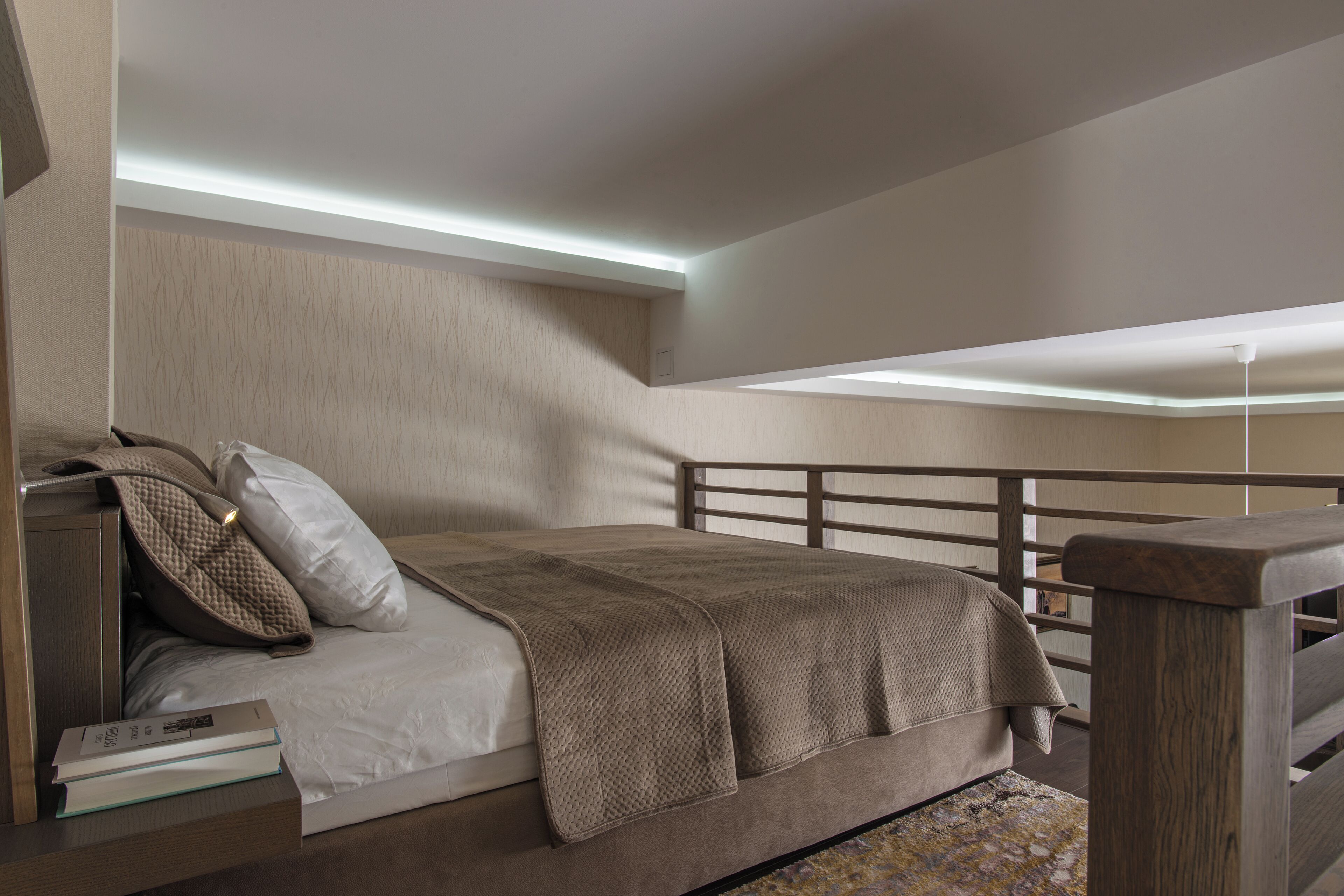 A bedroom with a bed, pillows, a bedside table, and a nightstand.