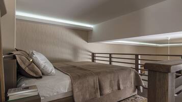 A bedroom with a bed, pillows, a bedside table, and a nightstand.