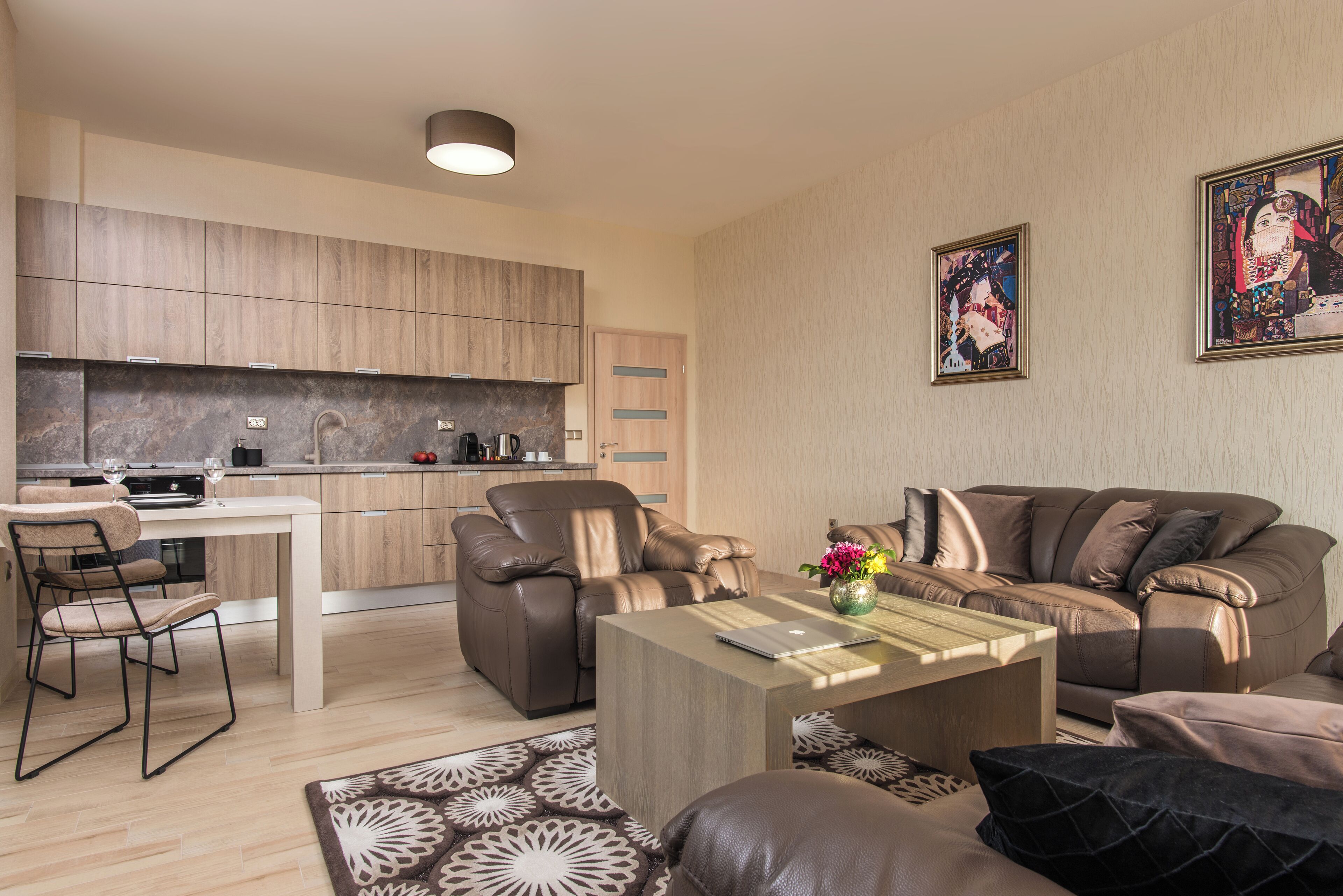 A modern living room with a sofa, a coffee table, and a dining area with a table and chairs.