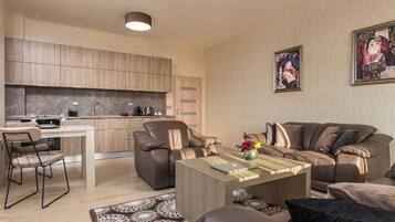 A modern living room with a sofa, a coffee table, and a dining area with a table and chairs.