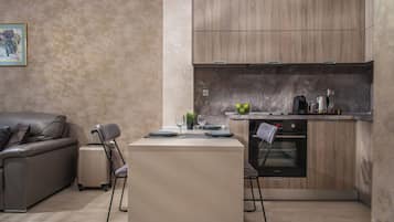 A compact kitchen with wooden cabinets, a built-in oven, and a dining area with a table set for two.