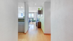 A modern kitchen with a dishwasher, a green sofa, and a dining area with a table and chairs. - ROYAL MARINE 2 314 Roses (Rosas / Roses)