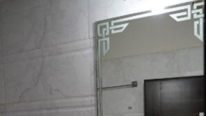 Un baño con lavamanos blanco, un espejo y un inodoro.