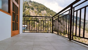Un balcón con baranda de metal que da a un paisaje montañoso.