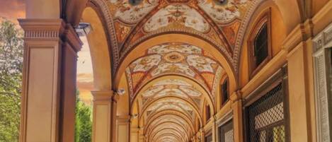 Un pasillo con arcos decorativos y un techo con diseños, que sugiere un edificio de importancia histórica o cultural.