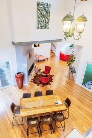Un comedor espacioso con una mesa y sillas de madera, un sofá rojo y una alfombra decorativa.
