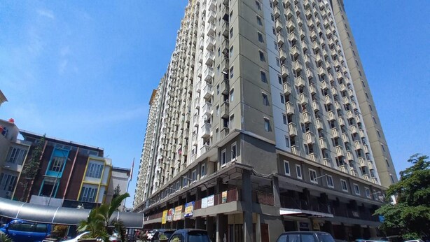 A high-rise residential building with multiple balconies and a ground-level commercial area. - Capital O 93760 Apartemen Gateway  (Bandung)