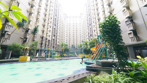 Un immeuble résidentiel doté d’une piscine, d’un terrain de jeux et d’espaces verts.
