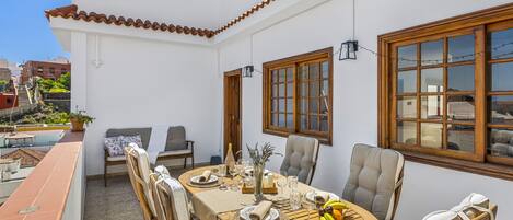 A dining area with a round table, chairs, and a view of the city.