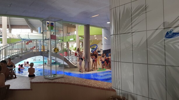 An indoor water park with a central pool, slides, and a play area. - Direkt auf dem Wasser - Un`s Lütt Goldfisch im "haifischbecken" (Röbel/Müritz)