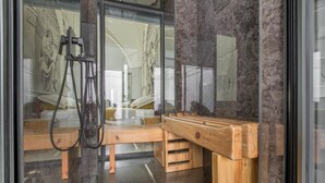 A modern bathroom with a wooden bench, a glass shower enclosure, and a marble floor. - 3737 La Catedral by Barbarhouse (Mesagne)