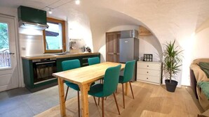Eine kompakte Küche mit Essbereich, Backofen und Kühlschrank.