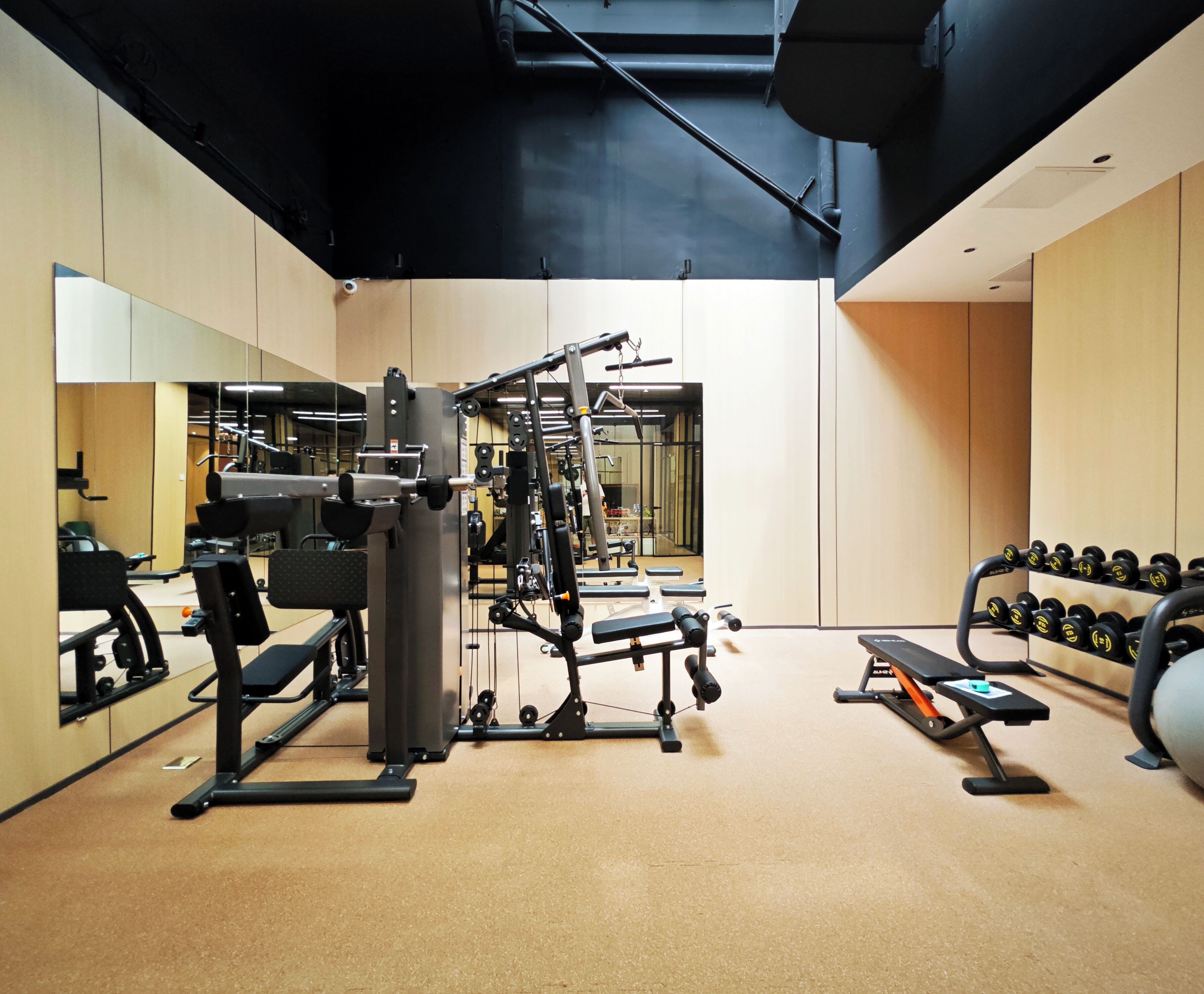 A gym with various exercise equipment, including weight machines and dumbbells.
