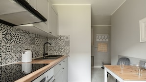 Eine moderne Küche mit gemustertem Rückwand, weißen Schränken und einer Holz Arbeitsplatte.