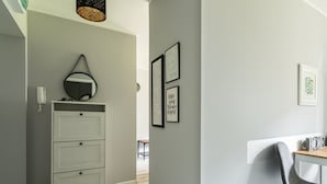Ein Flur mit einem weißen Schrank, einem Spiegel und gerahmten Motivationssprüchen an der Wand.