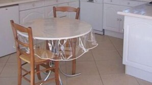 A kitchen with white cabinets, a round dining table with chairs, a microwave, and a dishwasher. - Country gite with enclosed garden located 1 hour 15 from the seaside (Mesnil-en-Ouche)