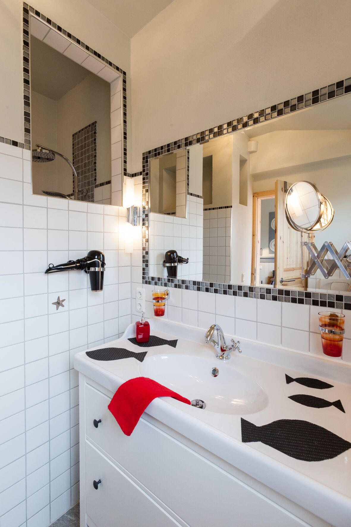 Un baño moderno con un tocador blanco, dos lavamanos, un espejo grande y un perchero para toallas.
