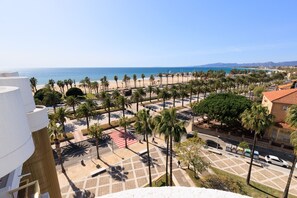 Eine Küstenansicht mit Palmen, einem Strand und einem Parkplatz.