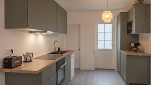Una cocina compacta con encimera de madera, horno empotrado, fregadero y microondas.