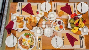 A breakfast table set with plates, cutlery, and a variety of food items including toast, eggs, and fruits. - Hotel View Bhaktapur (Suryabinayak)