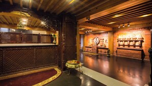 A traditional interior with a wooden ceiling, a reception desk, and a display of decorative items. - Hotel View Bhaktapur (Suryabinayak)