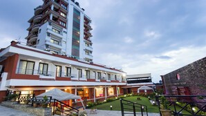 A hotel with a multi-story building, outdoor seating area, and a well-maintained garden. - Hotel View Bhaktapur (Suryabinayak)
