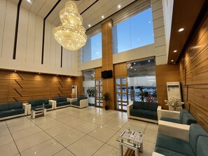 A spacious lobby with a high ceiling, a large chandelier, and seating areas. - Hotel Grand Darshan Vadodara (Vadodara)