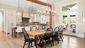 A spacious kitchen with a large island, wooden flooring, and modern cabinetry. - Spacious Home in Appalachian Mountains - Hot Tub, Firepit, on the Tocccoa River! (Suches)
