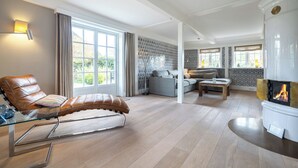Uma sala de estar moderna com uma poltrona de couro reclinável, uma lareira e um sofá.