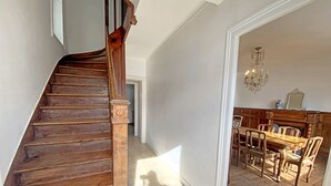 Eine Holztreppe führt zu einem Essbereich mit einer Chandelieber.