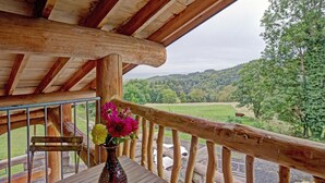 A wooden deck with a rustic railing overlooking a lush valley. - Charming Cottage with Jacuzzi in Forez Mountains (Saint-Jean-Soleymieux)