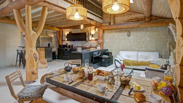 A rustic wooden interior with a dining area, kitchen, and living space. - Charming Cottage with Jacuzzi in Forez Mountains (Saint-Jean-Soleymieux)