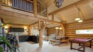 A spacious log cabin interior with a kitchen, dining area, and pool table. - Charming Cottage with Jacuzzi in Forez Mountains (Saint-Jean-Soleymieux)