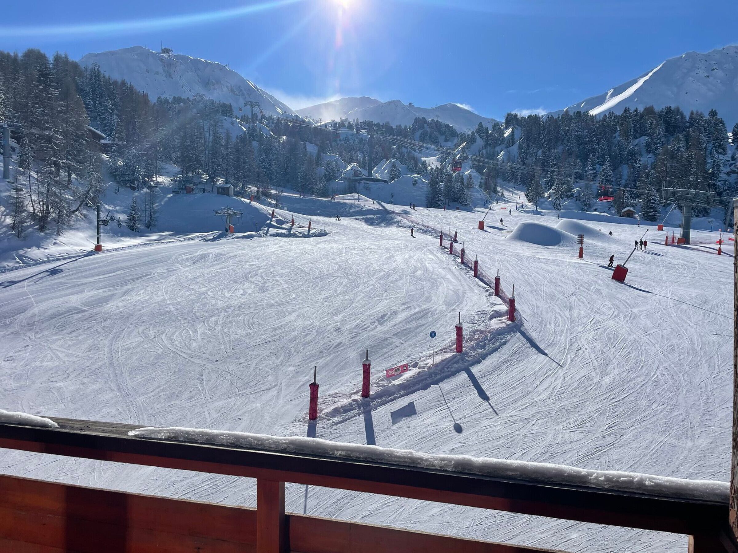 Ein mit Schnee bedeckter Skipisten mit Seilbahnen und Bäumen.