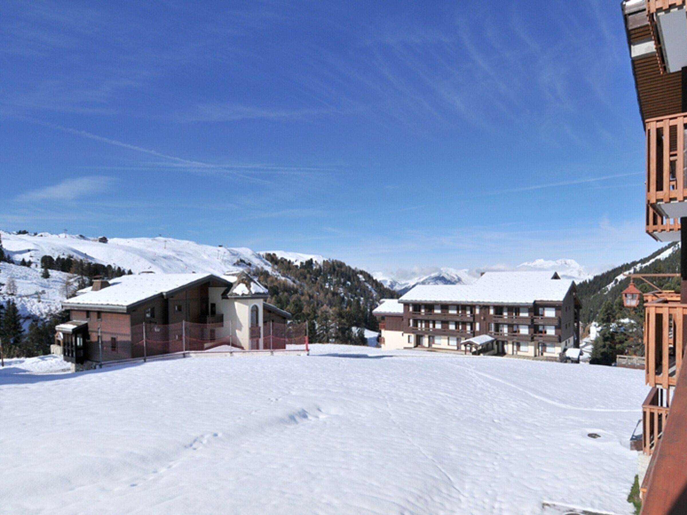 Estância de esqui coberta de neve, com um chalé grande e vistas para as montanhas.