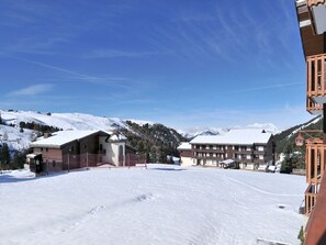 Une station de ski enneigée, dotée d’un grand chalet et offrant une vue sur les montagnes.