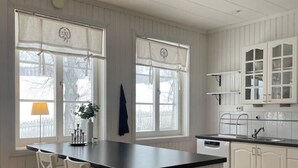 A kitchen with a central island, white cabinetry, and a wooden floor. - Timrå Farmhouse, large villa 222sqm in central Timrå yet on a private location. (Timrå, Västernorrlands län)