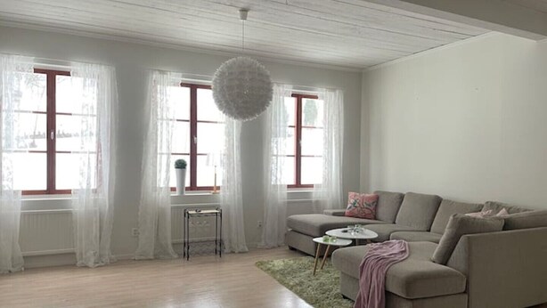 A modern living room with a sofa, a small table, and a hanging light fixture. - Timrå Farmhouse, large villa 222sqm in central Timrå yet on a private location. (Timrå, Västernorrlands län)