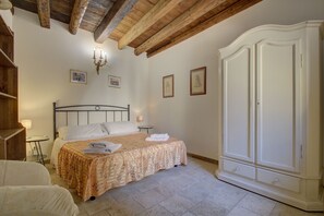 A bedroom with a bed, a wardrobe, a chandelier, and framed pictures on the wall. - SPIRAL-Canal-View (Venice)