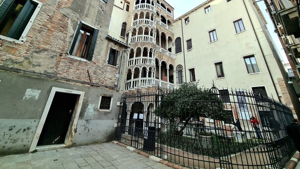 Un edificio histórico con una torre central que cuenta con varios balcones y ventanas arqueadas.