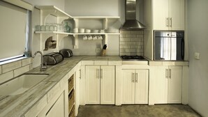 A kitchen with white cabinets, a stainless steel oven, and a tiled backsplash. - Sandy Feet Langebaan 8-sleeper (Langebaan)